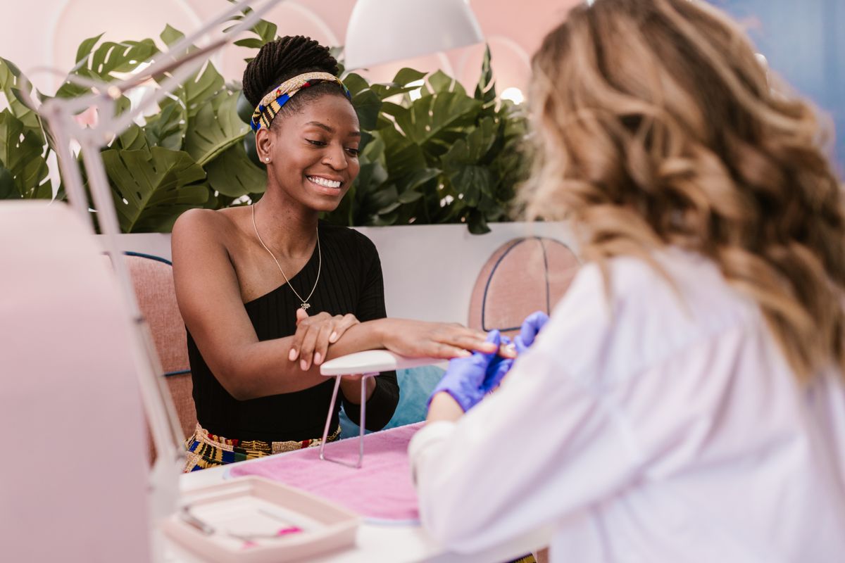 African client receiving professional nail care